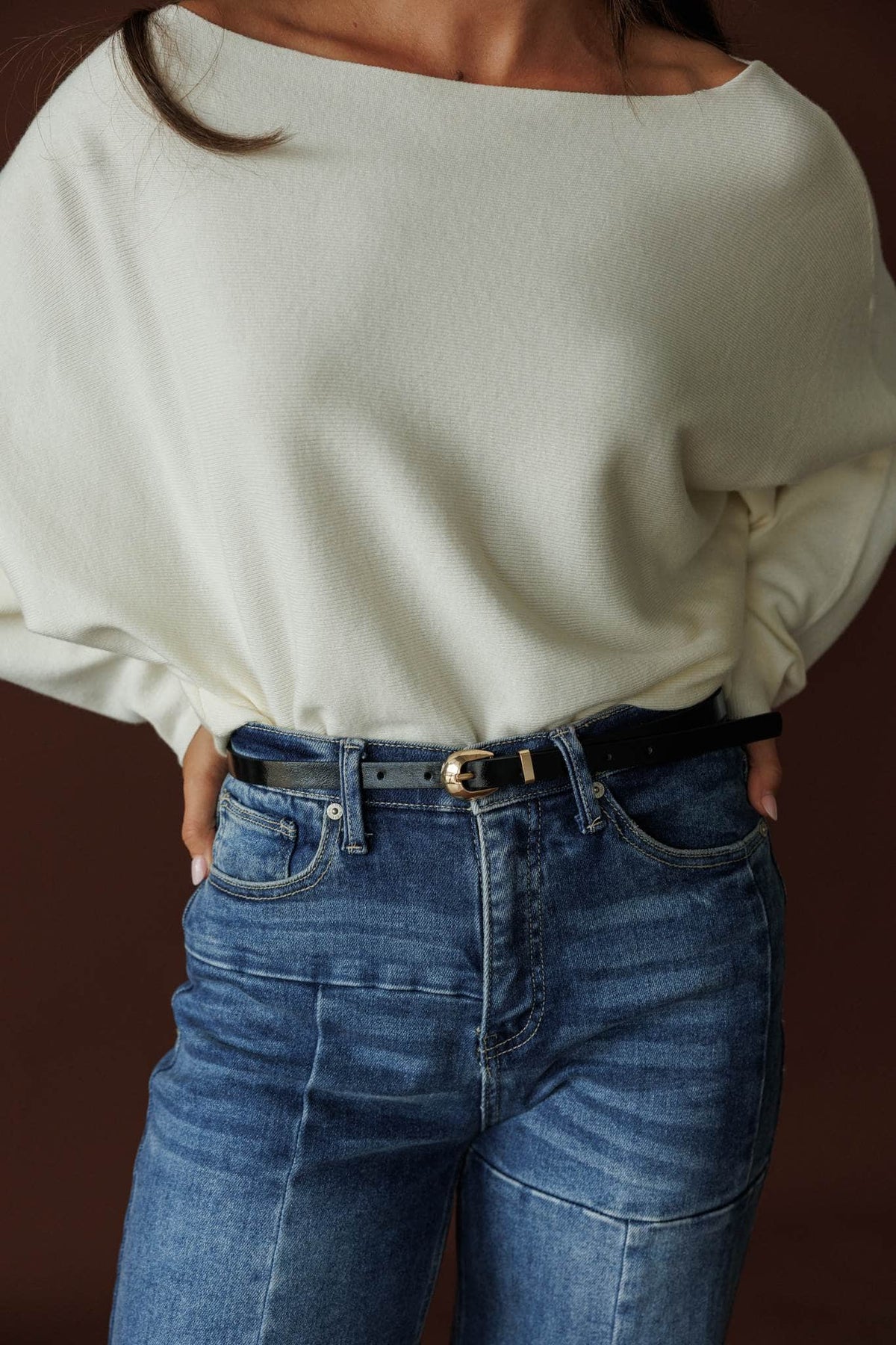 Paris Belt, in black shine, close front view of the belt over denim