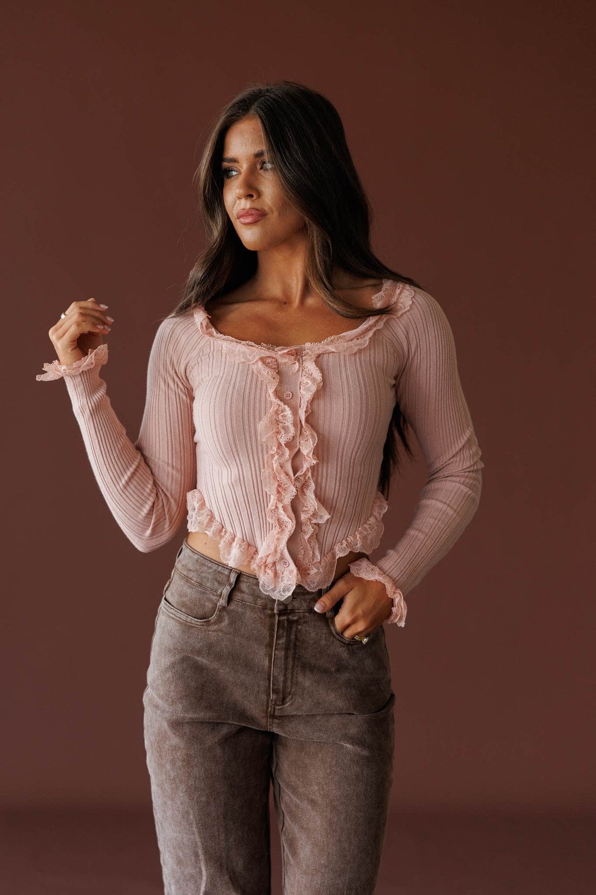 Colette Ruffle Top in misty rose, front view on model with one hand raised