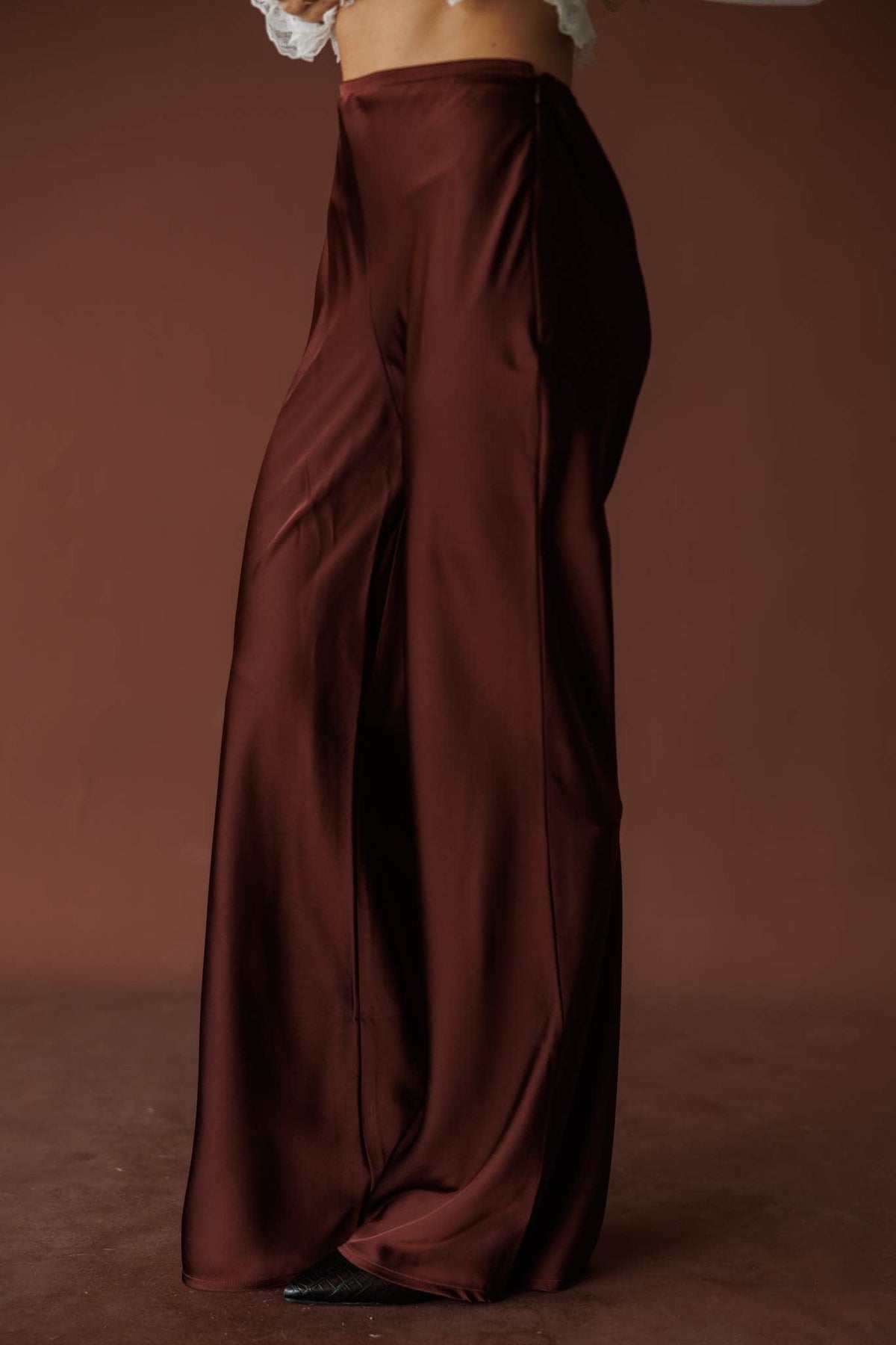 Nightcap Satin Trouser, in rum raisin, side view of the wide leg