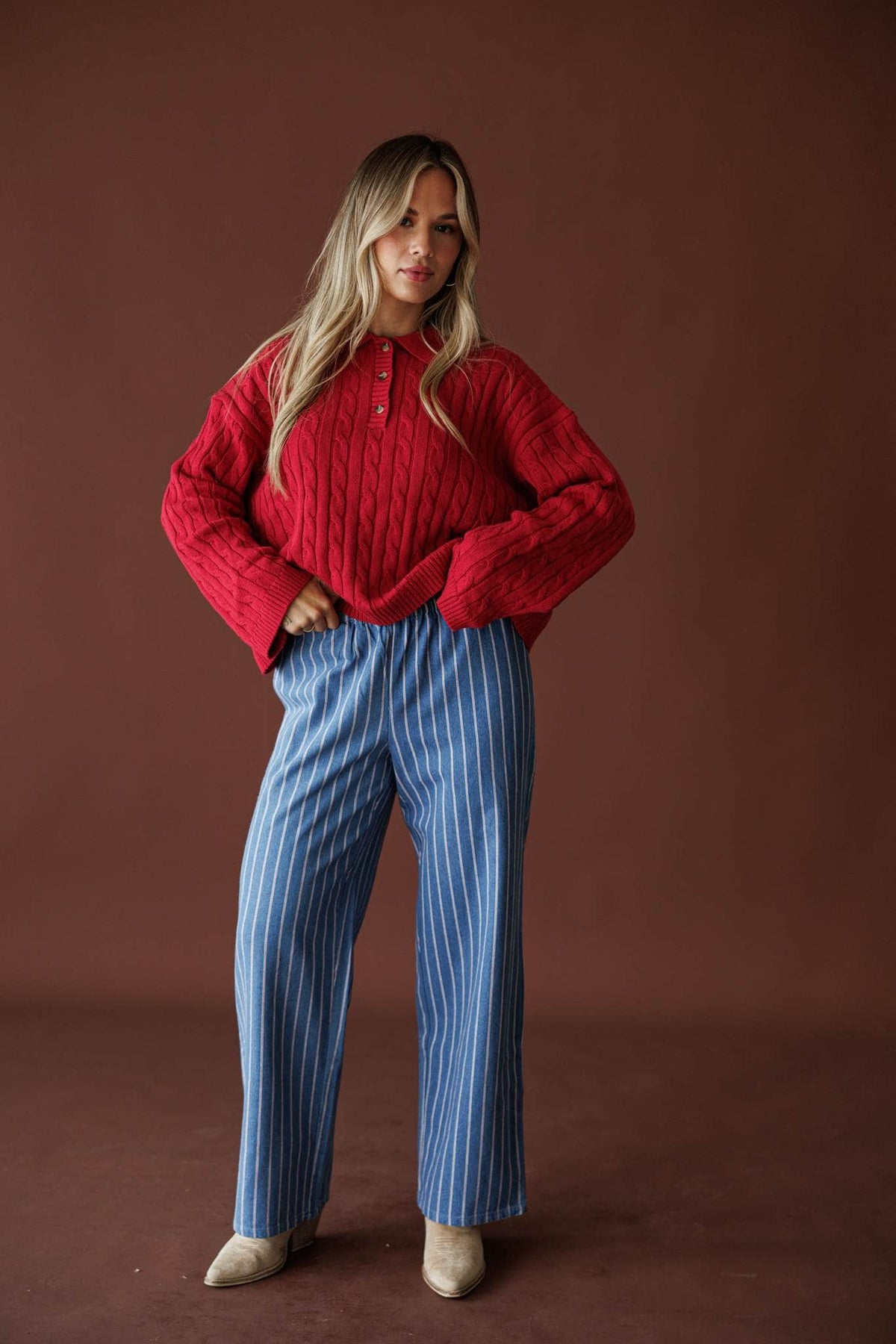Ticking Stripe Denim Pants in washed blue, full-length view with a red cable knit sweater