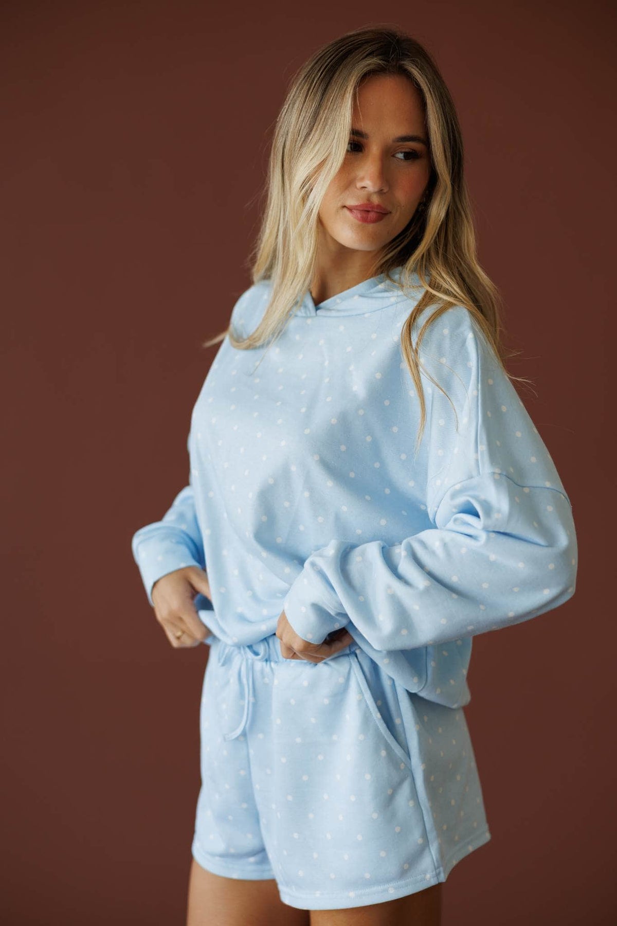 Baby Blue Polkadot Hoodie in baby blue, front view on model with hand at the waist