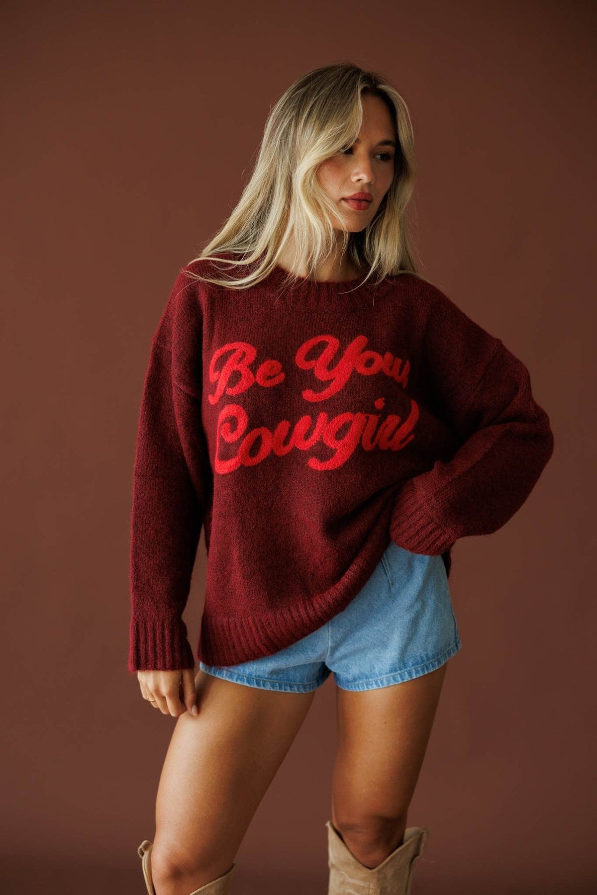 Be Your Cowgirl Sweater in burgundy, full-length view with denim shorts and tan boots