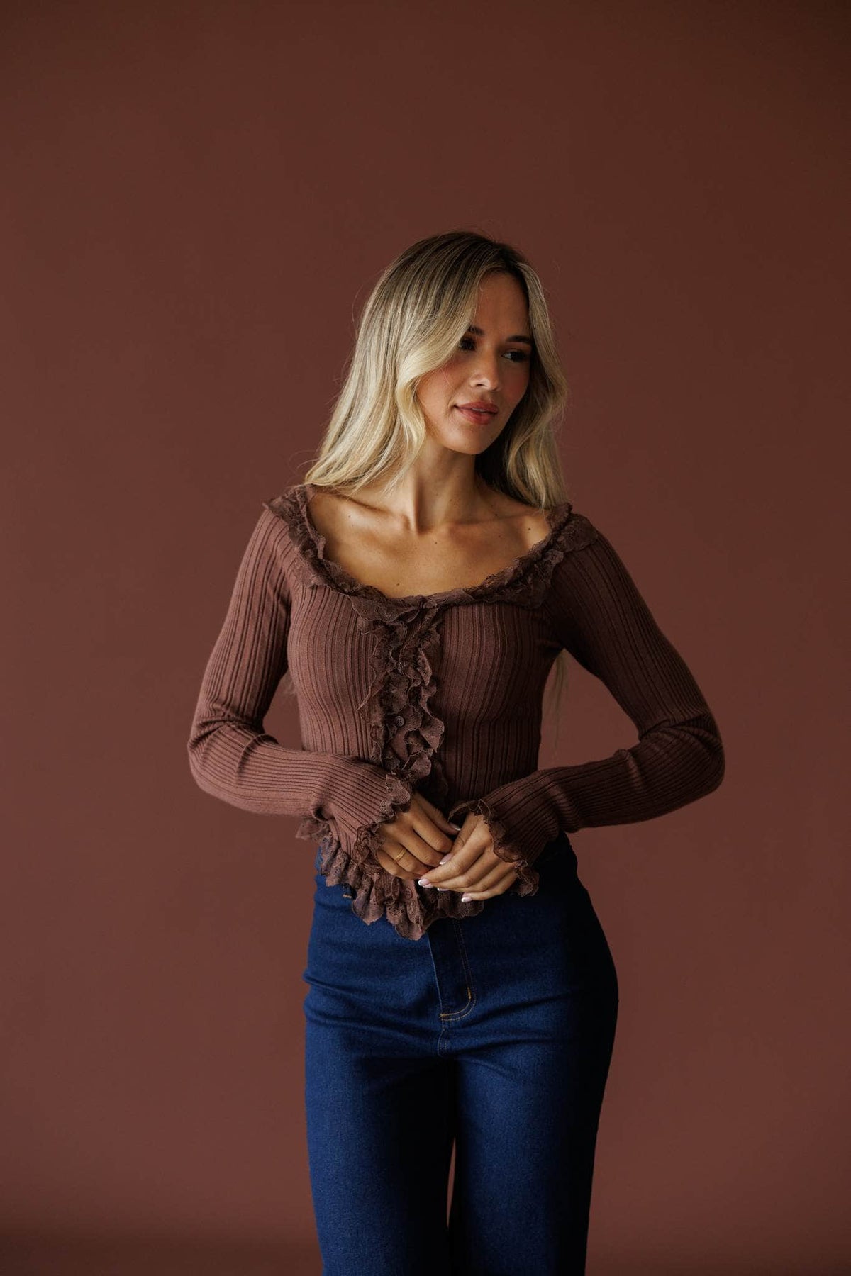 Colette Ruffle Top in mocha, front view on model with hands clasped