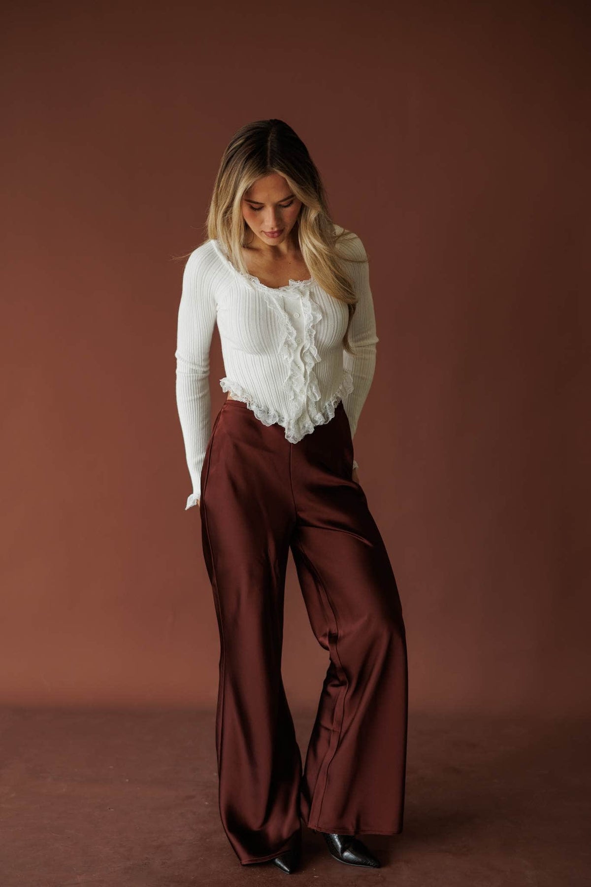 Nightcap Satin Trouser, in rum raisin, full-length front view with a cream top