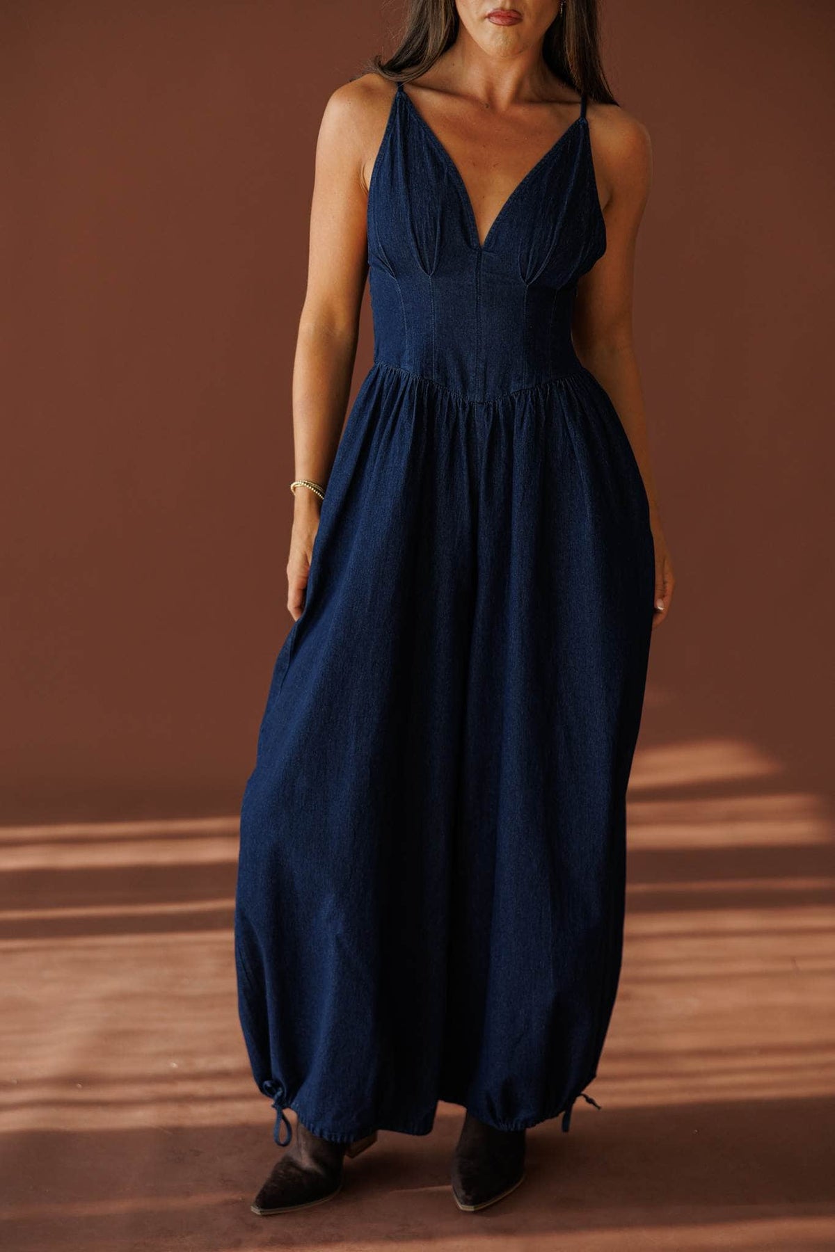 Miles From Home Jumpsuit in dark denim, front close-up of the V neck and straps