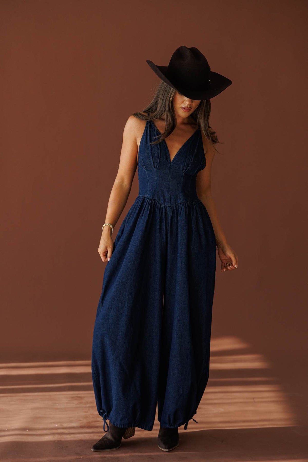 Miles From Home Jumpsuit in dark denim, full-length view with tall boots