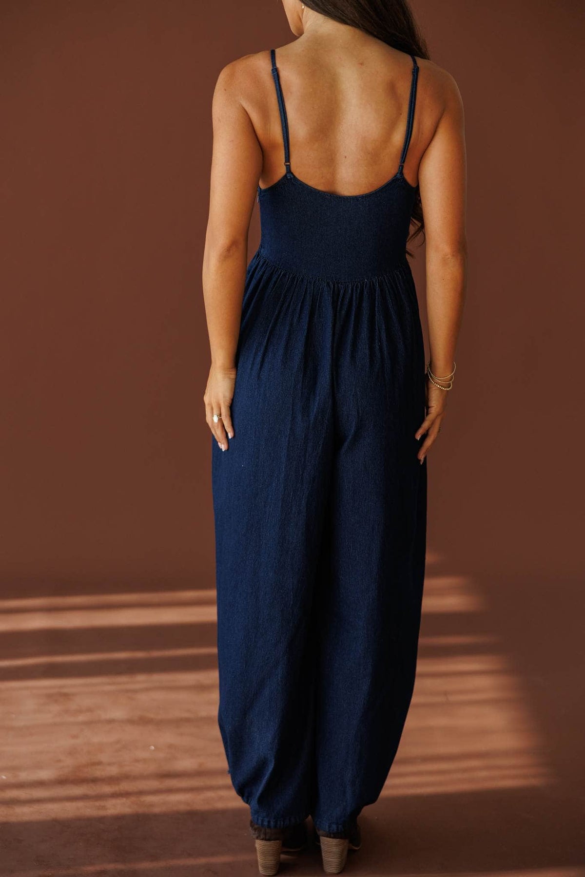 Miles From Home Jumpsuit in dark denim, back view showing the open back jumpsuit