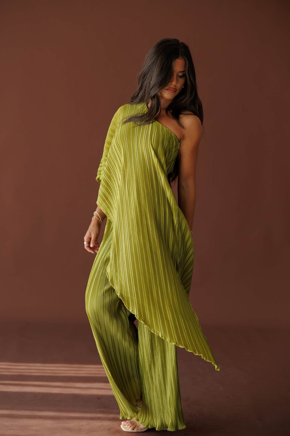Muse Moments Pleated Top in olive, side view showing the asymmetric pleated hem
