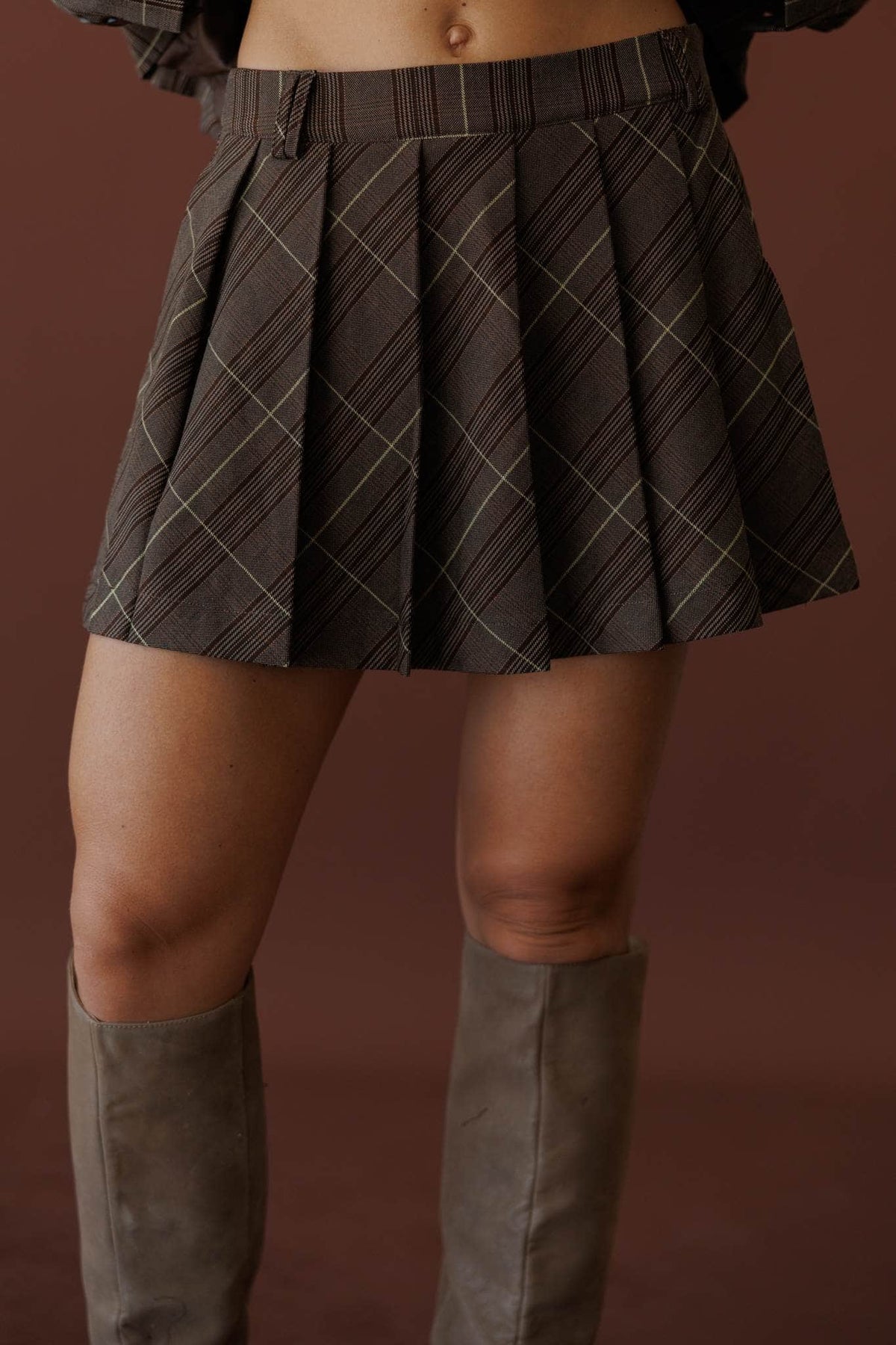 Board Meeting Plaid Skort, front view of the box pleats with tall boots