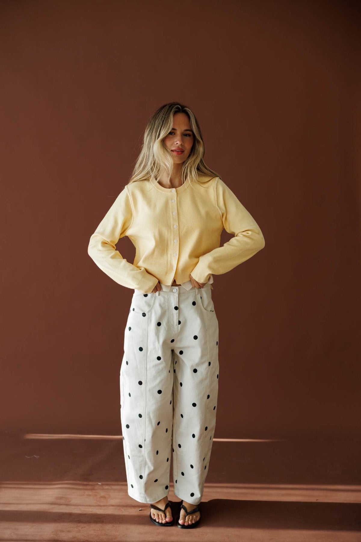 On The Dot Barrel Pants in cream and black dot, full-length view with a yellow cardigan