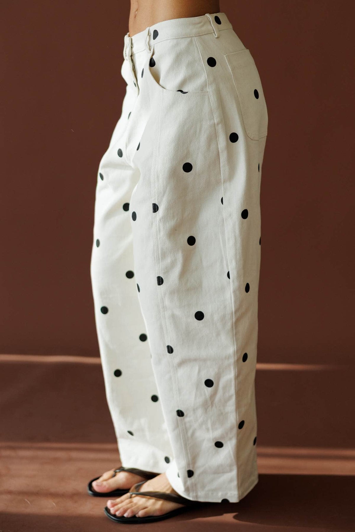 On The Dot Barrel Pants in cream and black dot, side view showing the dotted barrel leg