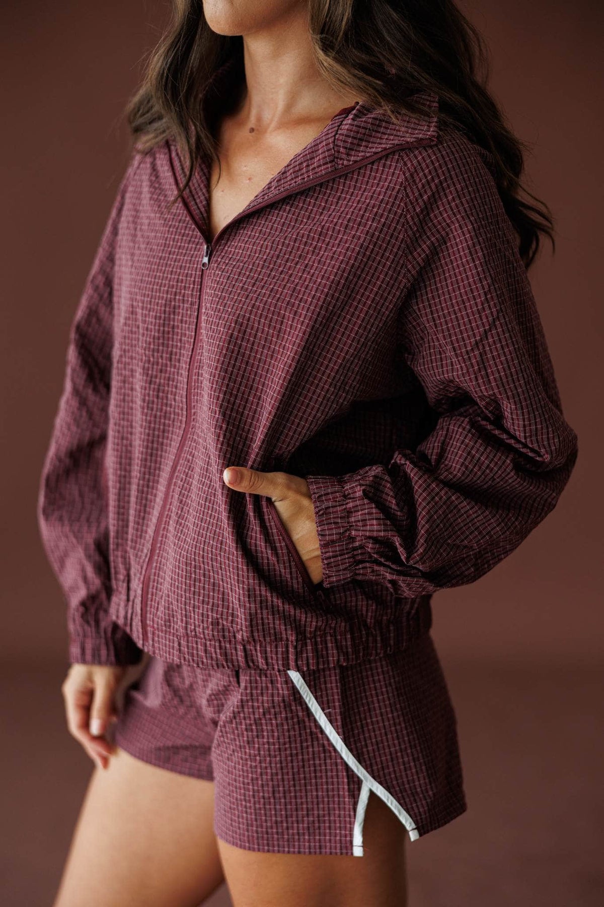 Off Duty Hooded Jacket in burgundy, front close-up of the zip and elastic hem