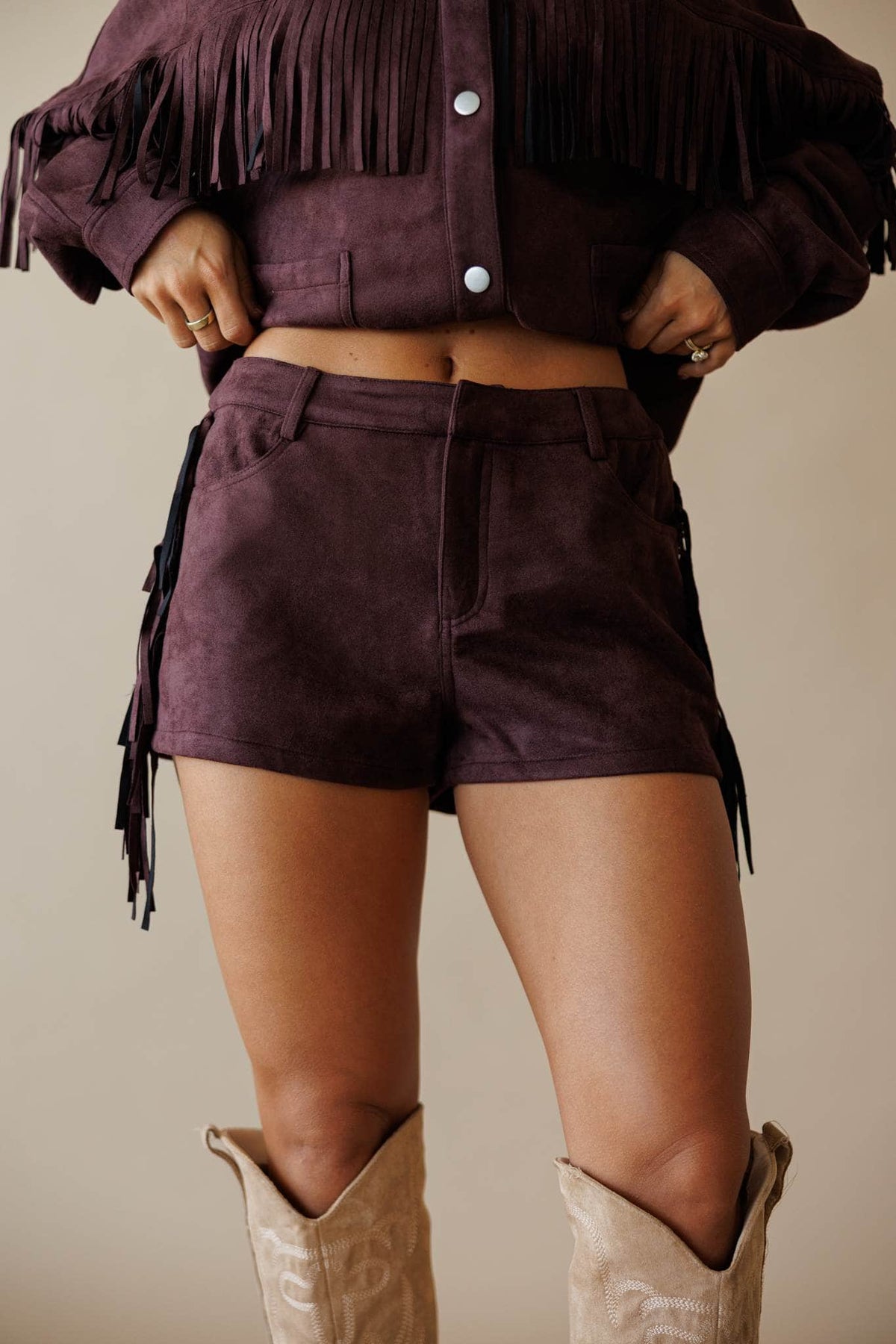 Dark brown suede shorts with fringe, front view