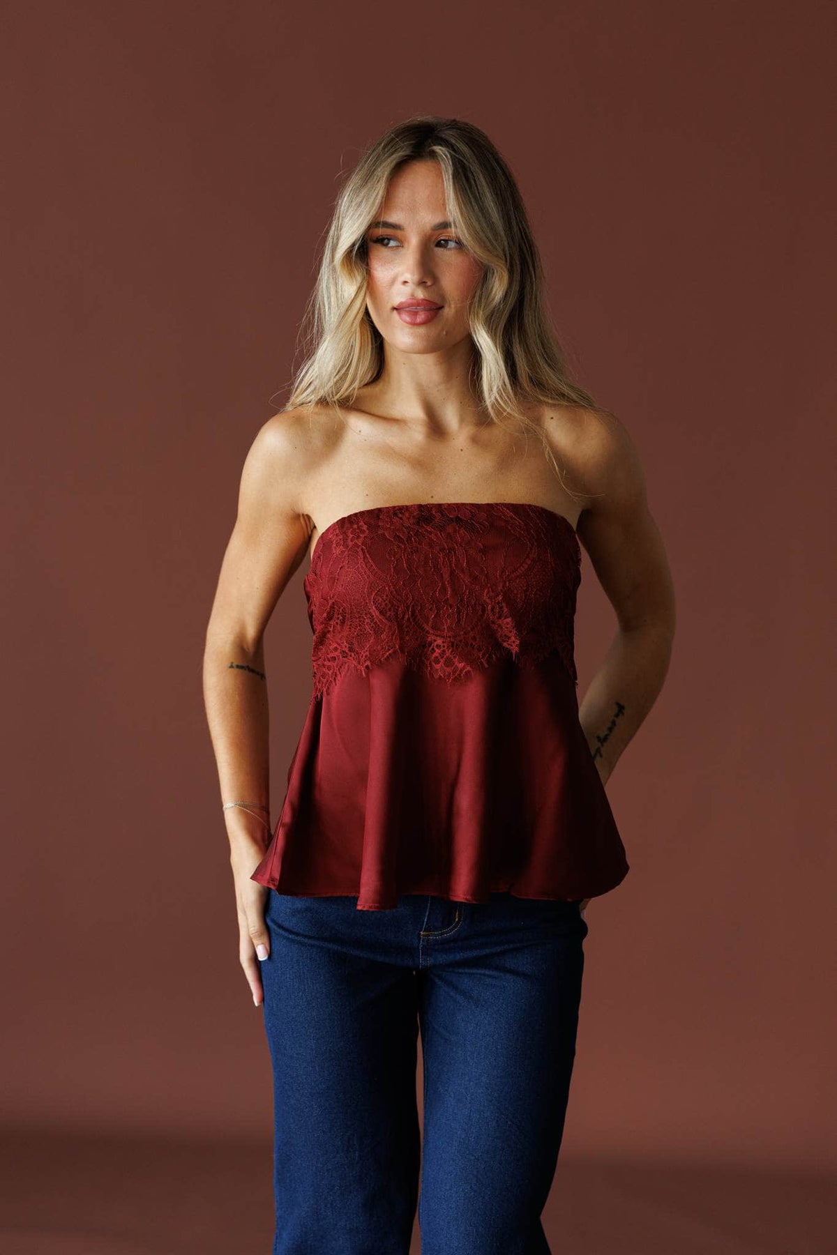 Satin Secrets Tube Top in wine, front view on model with dark wash jeans