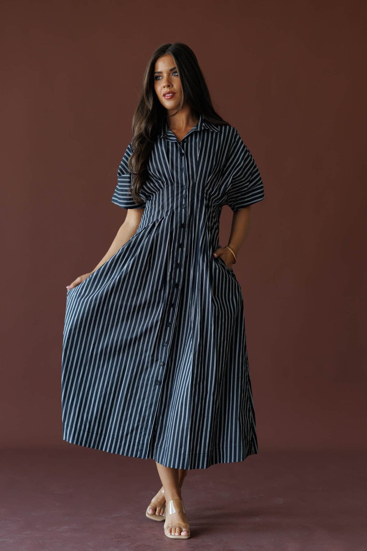 Striped Dolman Sleeve Midi Dress in black stripe, full-length view on model holding the skirt