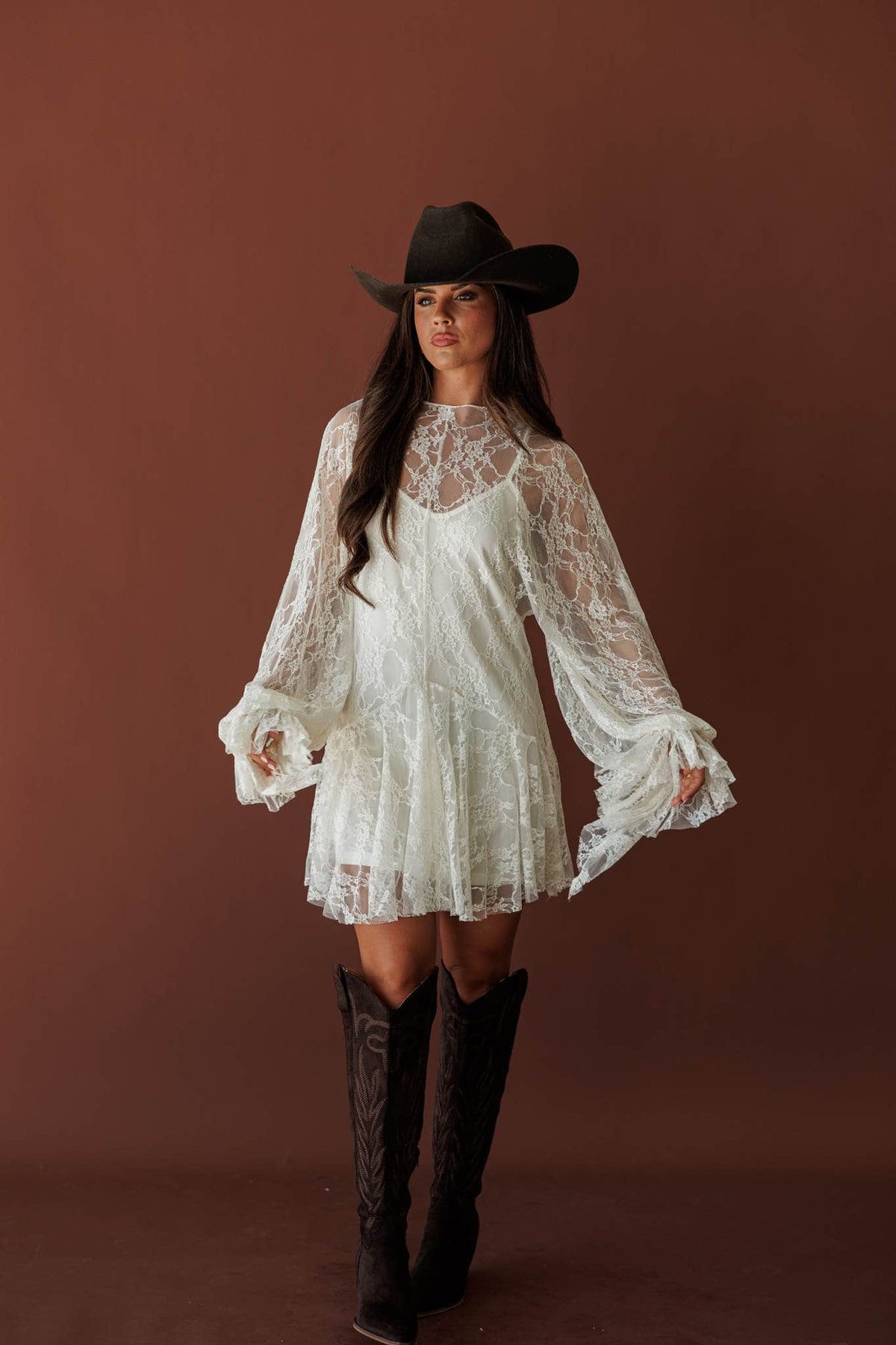 Lace Legend Mini Dress, in cream, full-length view with a black hat and tall boots