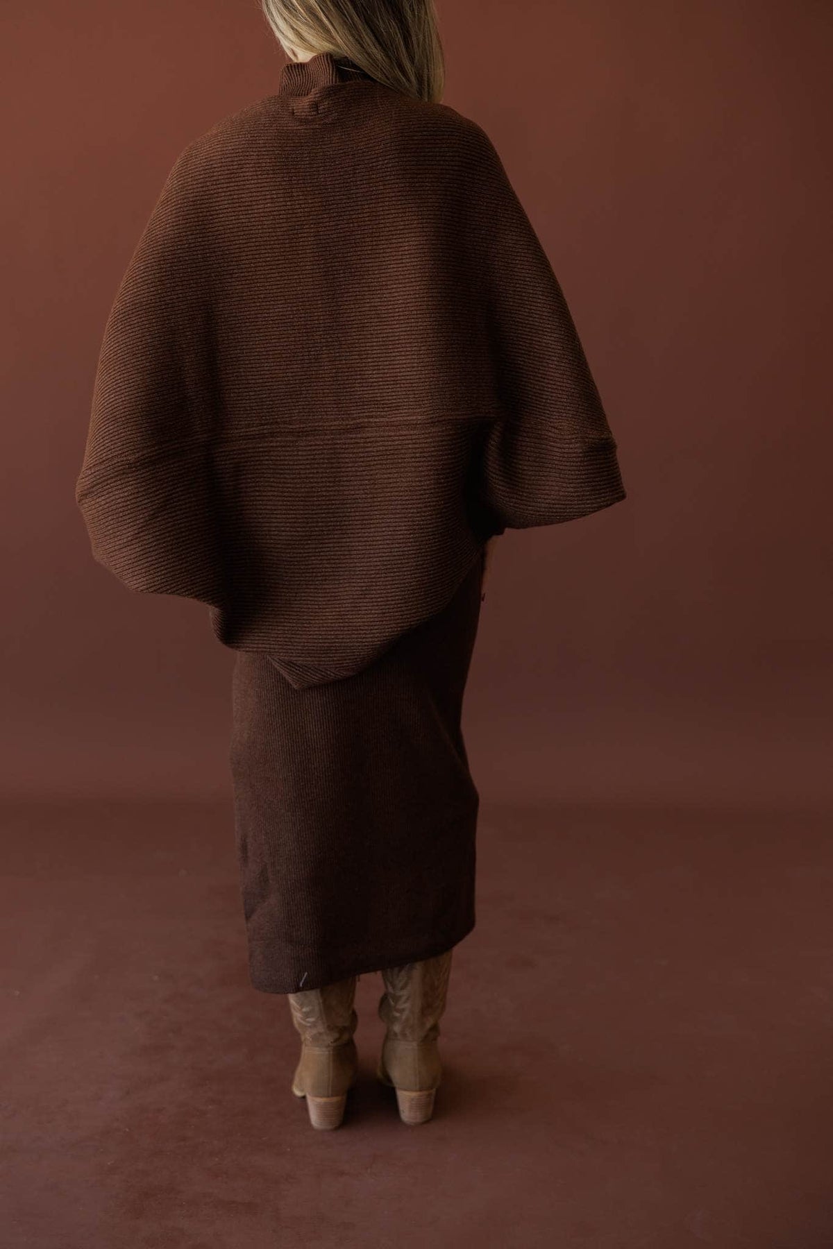 Serving Looks Shrug, in chocolate, back view of the draped sleeves